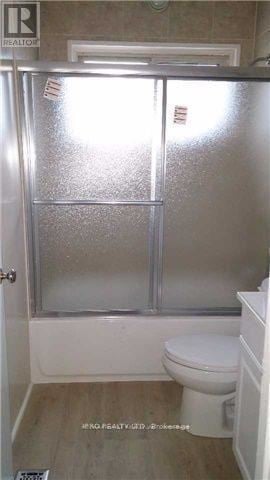 Richmond Hill (Harding) triplex for rent - A bathroom with a toilet and a glass door shower.