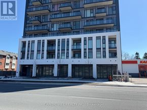 Toronto (West Hill) condo for rent - A tall white building with a glass facade is the main focus of the image.