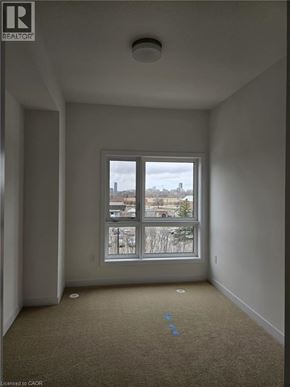 Kitchener townhouse for rent - A room with a window and a carpeted floor.