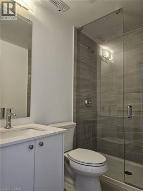 Kitchener townhouse for rent - A white toilet sits next to a sink in a bathroom.