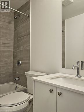 Kitchener townhouse for rent - A white toilet sits next to a sink in a bathroom.