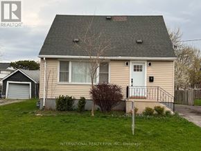 St. Catharines (Secord Woods) apartment for rent - A beige house with a white door and a small tree in front.