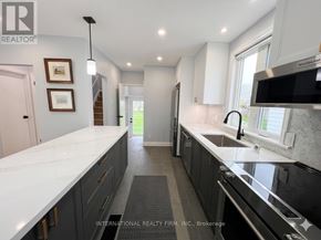 St. Catharines (Secord Woods) apartment for rent - A modern kitchen with dark cabinets and a white countertop.