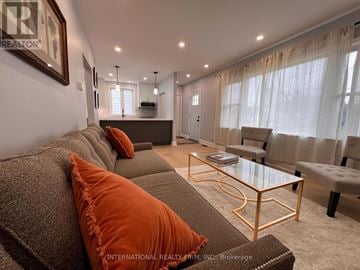 St. Catharines (Secord Woods) apartment for rent - A living room with a grey couch and orange pillows.