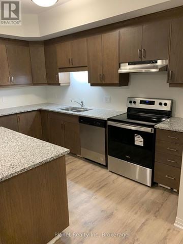 Cambridge townhouse for rent - A kitchen with a stove top oven and a sink.