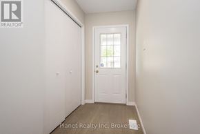 Guelph (Clairfields/Hanlon Business Park) townhouse for rent - A white door with a glass window is in the middle of a room with white walls.