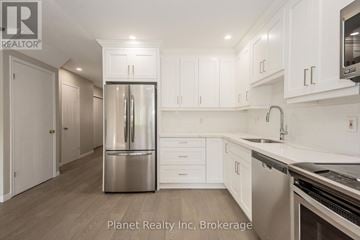 Guelph (Clairfields/Hanlon Business Park) townhouse for rent - A kitchen with white cabinets and a stainless steel refrigerator.