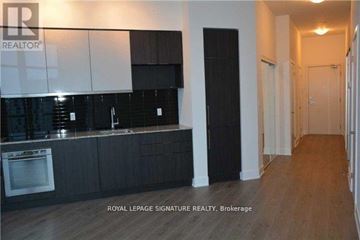 Toronto (Banbury-Don Mills) condo for rent - A kitchen with black cabinets and a white wall.