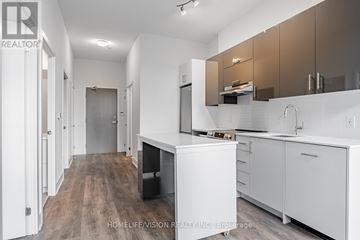 Toronto (Don Valley Village) condo for rent - A modern kitchen with white cabinets and a wooden floor.