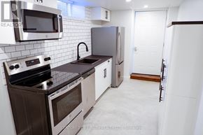 Innisfil (Lefroy) multi-family for rent - A kitchen with a stove top oven, microwave, and refrigerator.
