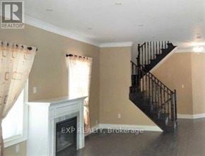 Vaughan (Vellore Village) apartment for rent - A living room with a staircase and a fireplace.