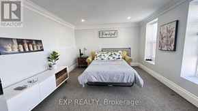 Niagara Falls (Dorchester) apartment for rent - A bedroom with a bed, nightstand, and a wall-mounted shelf with a plant on it.