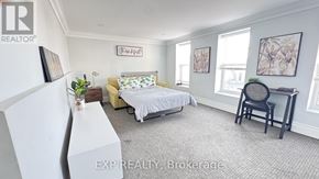Niagara Falls (Dorchester) apartment for rent - A bedroom with a bed, chair, and a framed picture on the wall.