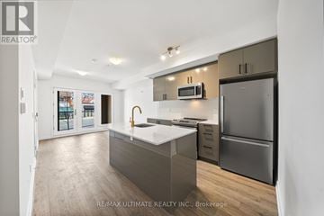 Toronto (Birchcliffe-Cliffside) townhouse for rent - A modern kitchen with a refrigerator, microwave, and oven.