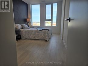 Burlington (Alton) condo for rent - A bedroom with a large bed and a view of the ocean through the windows.