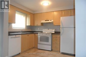 Kitchener townhouse for rent - A kitchen with wooden cabinets and white appliances.