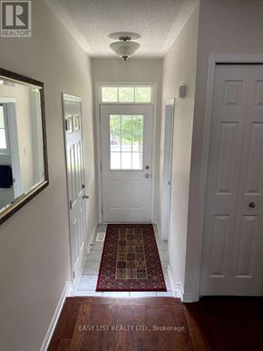 Ottawa townhouse for rent - A hallway with a rug and a mirror on the wall.