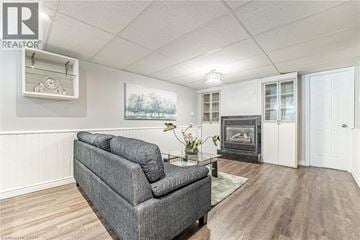 Hamilton apartment for rent - A grey couch in a living room with a fireplace and a painting on the wall.
