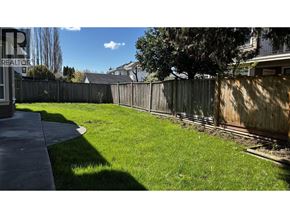 Richmond apartment for rent - A backyard with a wooden fence and a green lawn.