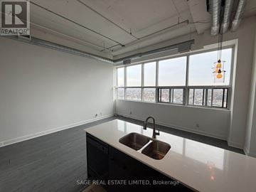 Toronto (Niagara) condo for rent - A kitchen with a sink and a window overlooking a cityscape.