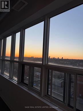 Toronto (Niagara) condo for rent - A view of a city skyline through a window at sunset.