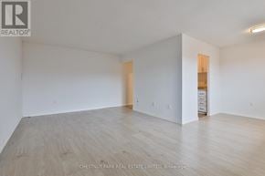 Oshawa (Lakeview) condo for rent - A large empty room with wood flooring and white walls.