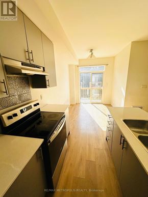 Oshawa (Donevan) townhouse for rent - A kitchen with a stove top oven and a sink.