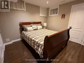 Newmarket (Woodland Hill) apartment for rent - A bedroom with a bed, nightstand, and lamp.