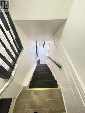 St. Catharines (E. Chester) multi-family for rent - A staircase with a black and white striped railing.