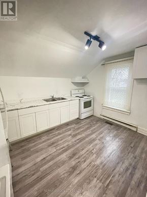 St. Catharines (E. Chester) multi-family for rent - A kitchen with white cabinets and a wooden floor.