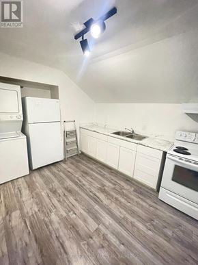 St. Catharines (E. Chester) multi-family for rent - A kitchen with white appliances and wood flooring.