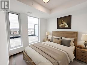 Burlington (Alton) condo for rent - A bedroom with a large bed, a window with a view, and a painting on the wall.