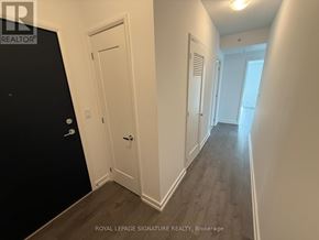 Hamilton (Corktown) condo for rent - A hallway with white walls and wood flooring.