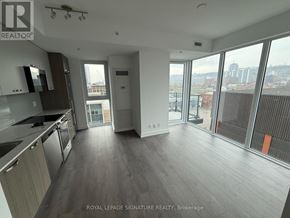 Hamilton (Corktown) condo for rent - A spacious kitchen and living room with a view of the city.
