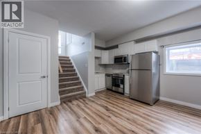Kitchener apartment for rent - A kitchen with a refrigerator, microwave, and oven.