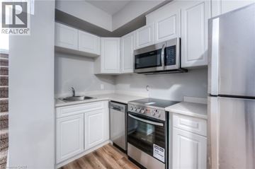 Kitchener apartment for rent - A modern kitchen with white cabinets and stainless steel appliances.