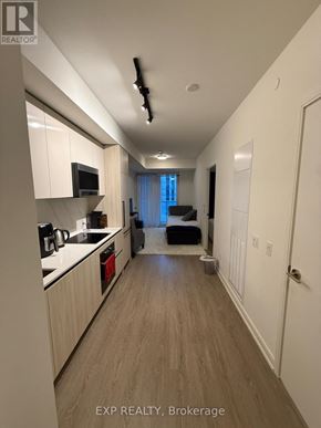 Toronto (Waterfront Communities) condo for rent - A kitchen with white cabinets and a microwave.