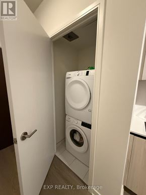 Toronto (Waterfront Communities) condo for rent - A white washing machine in a small laundry room.