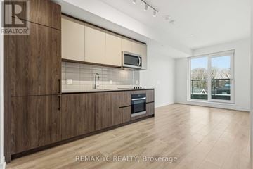 Toronto (South Riverdale) condo for rent - A kitchen with wooden cabinets and a microwave above the oven.