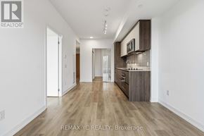 Toronto (South Riverdale) condo for rent - A spacious kitchen with wooden floors and white walls.