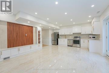 Toronto (Centennial Scarborough) apartment for rent - A spacious kitchen with white cabinets and a wooden door.
