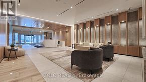 Toronto (Regent Park) condo for rent - A modern living room with a large grey sofa and a wooden floor.