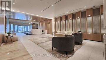 Toronto (Regent Park) condo for rent - A modern living room with a large grey sofa and a wooden floor.