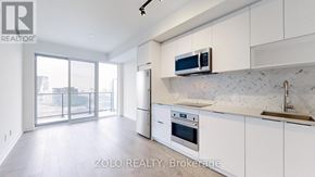 Toronto (Regent Park) condo for rent - A modern kitchen with white cabinets and a marble backsplash.