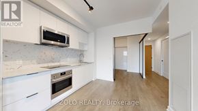 Toronto (Regent Park) condo for rent - A modern kitchen with white cabinets and a marble backsplash.