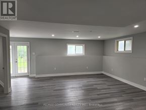 Innisfil (Alcona) apartment for rent - A spacious room with wooden flooring and white walls, ready for renovation.
