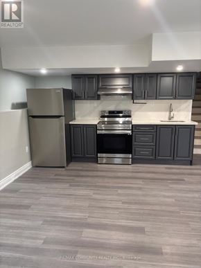 Innisfil (Alcona) apartment for rent - A kitchen with a refrigerator, stove, and cabinets.