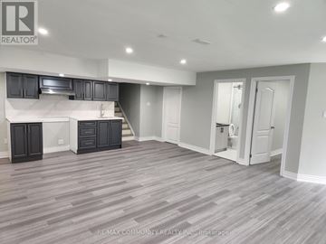 Innisfil (Alcona) apartment for rent - A spacious kitchen with dark wood cabinets and a white island.