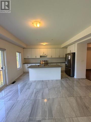 Oshawa (Eastdale) apartment for rent - A spacious kitchen with a marble floor and a refrigerator on the right side.