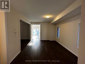 Oshawa (Eastdale) apartment for rent - A spacious room with wooden floors and white walls.